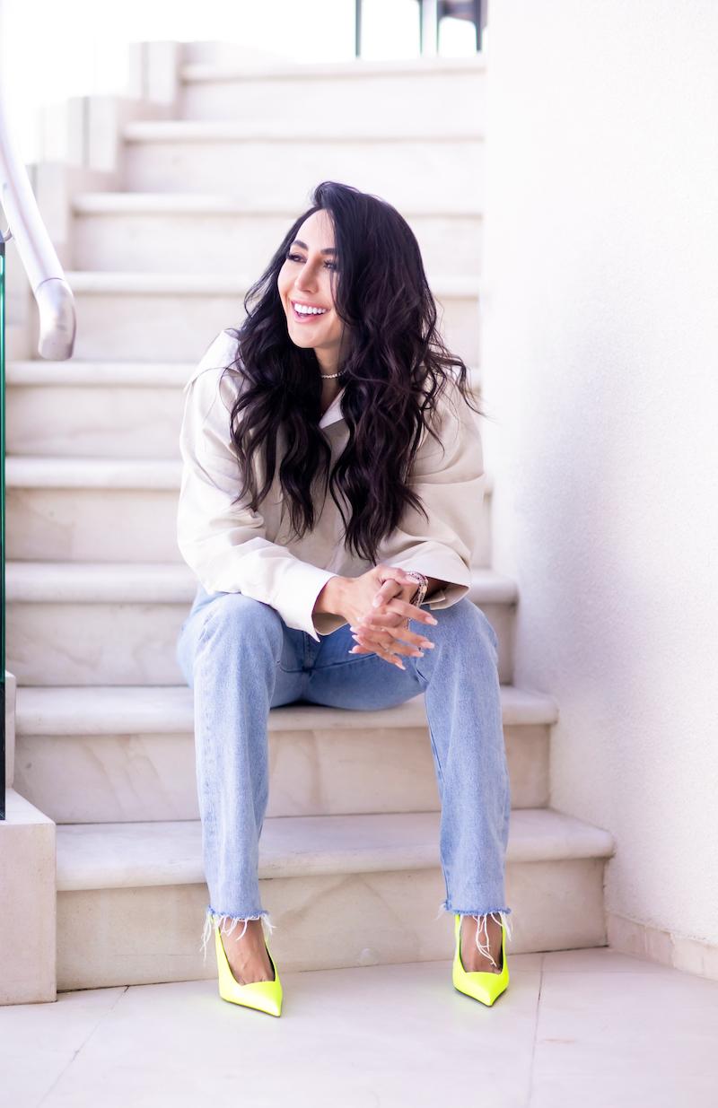 Durana Elmi sits on outdoor marble staircase while smiling